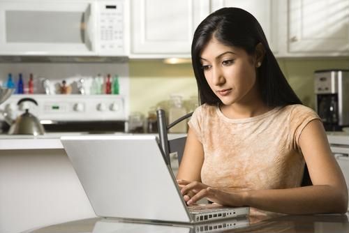 woman working on a laptop at a kitchen island