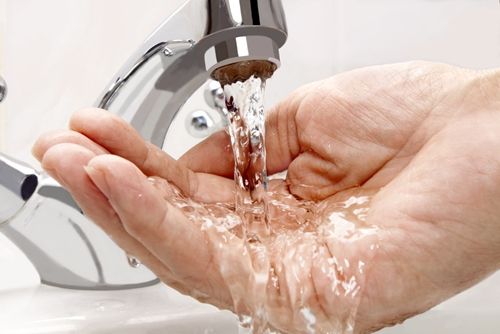 hand under a faucet with running water