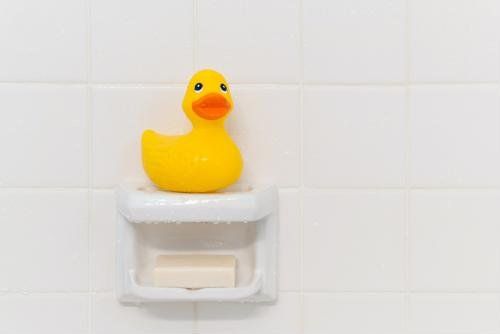 rubber duck sitting on a soap ledge